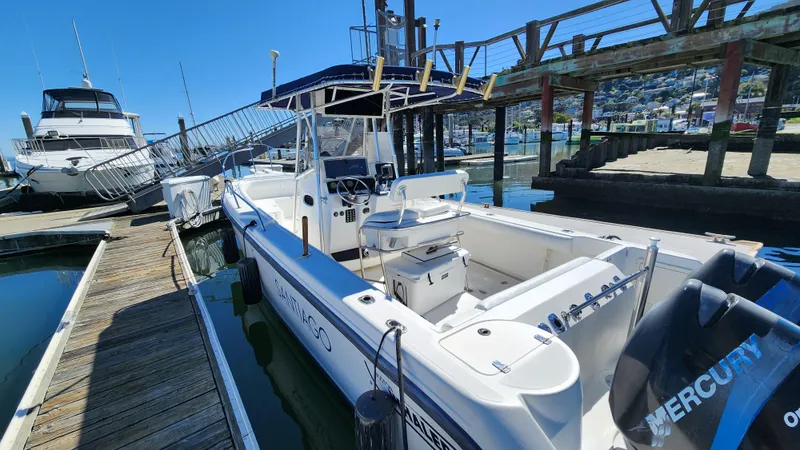 Slide: The Image of 2001 Boston Whaler 26 Outrage docked at marina, featuring spacious deck and Mercury engine. - 3