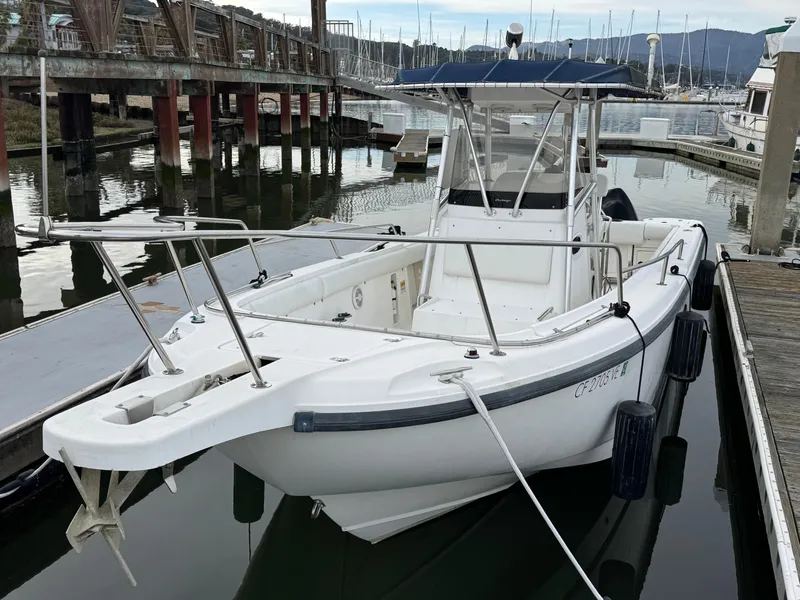 Slide: The Image of 2001 Boston Whaler 26 Outrage boat docked in a marina, featuring a center console. - 8