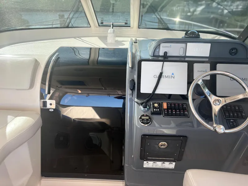 Slide: The Image of 2012 Pursuit OS 345 Offshore boat cockpit with Garmin navigation system and steering wheel. - 10