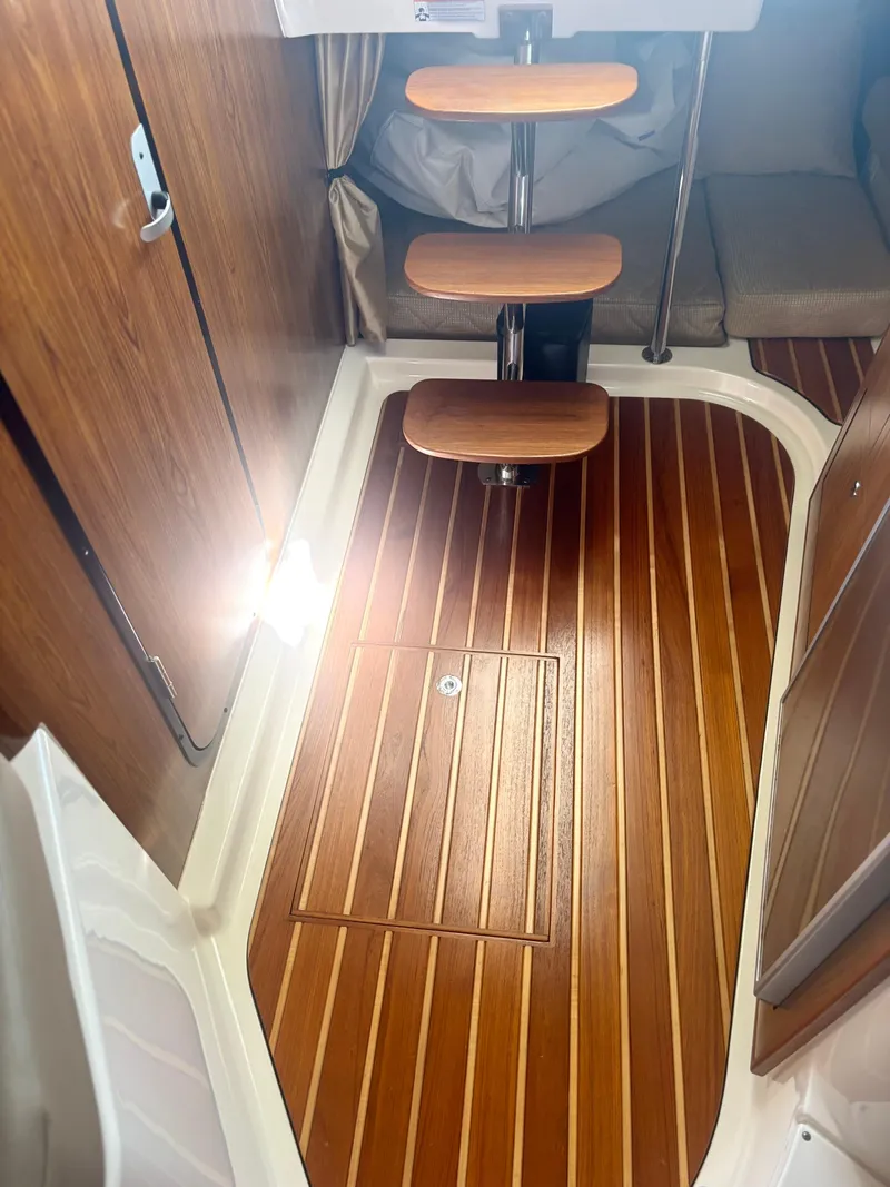 Slide: The Image of 2012 Pursuit OS 345 Offshore cabin interior with wooden flooring and steps. - 11