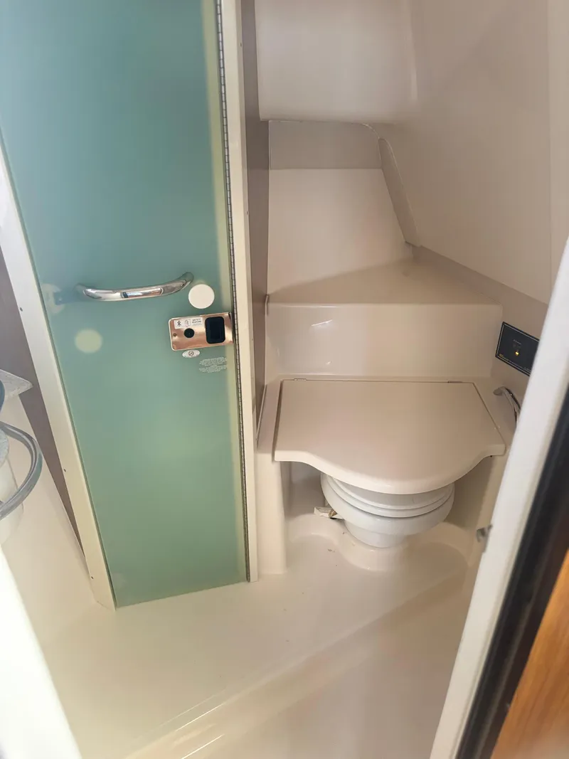 Slide: The Image of 2012 Pursuit OS 345 Offshore boat bathroom with compact toilet and modern design. - 18