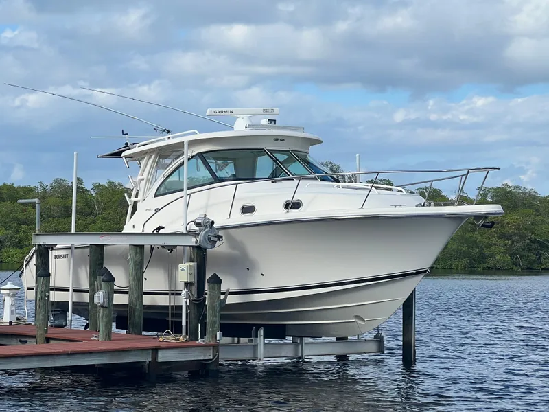Slide: The Image of 2012 Pursuit OS 345 Offshore boat docked on a calm lake. - 3