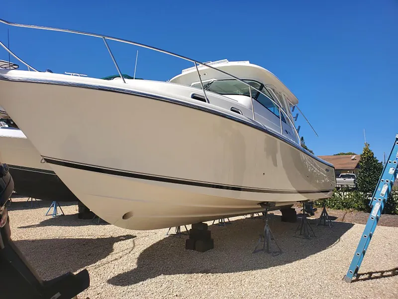 Slide: The Image of 2012 Pursuit OS 345 Offshore boat on stands under clear blue sky. - 4