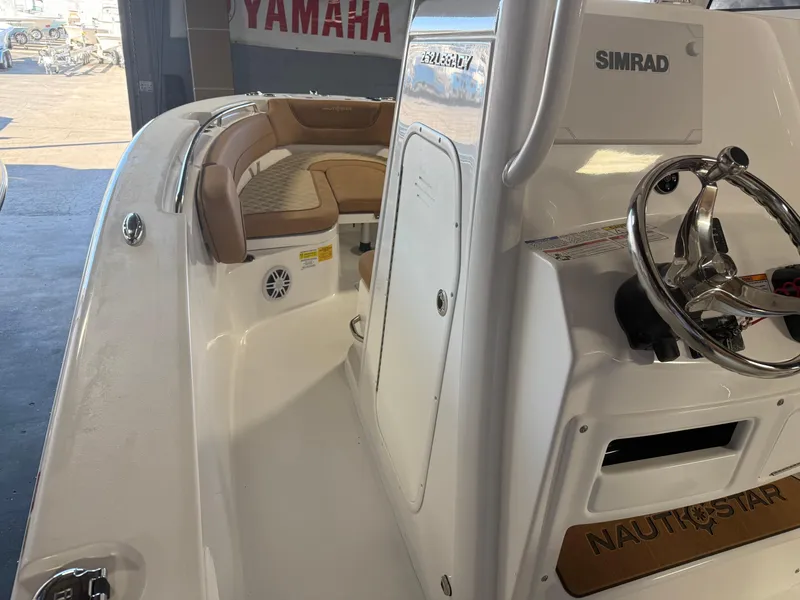 Slide: The Image of 2025 NauticStar 252 Legacy boat interior with steering wheel and seating. - 11
