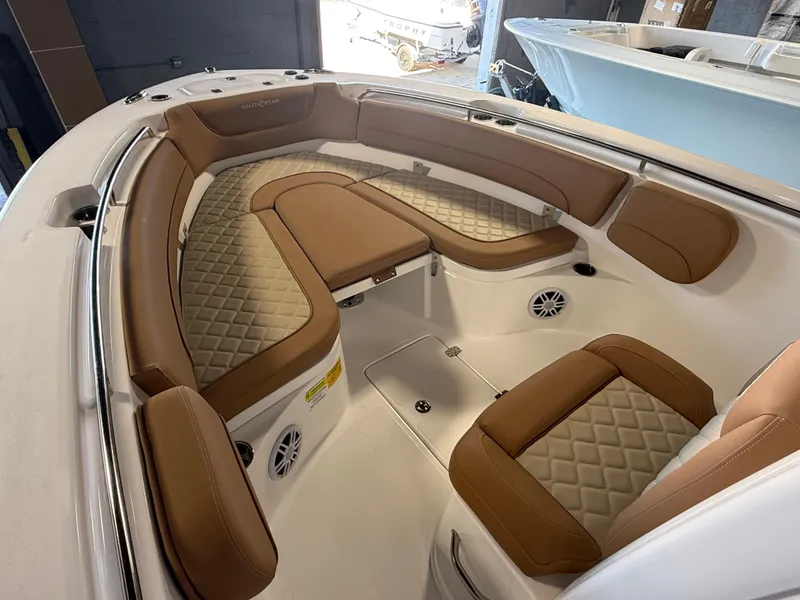 Slide: The Image of 2025 NauticStar 252 Legacy boat interior with tan quilted seating and speakers. - 12
