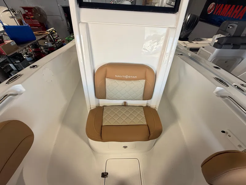 Slide: The Image of 2025 NauticStar 252 Legacy boat interior with tan cushioned seating. - 14