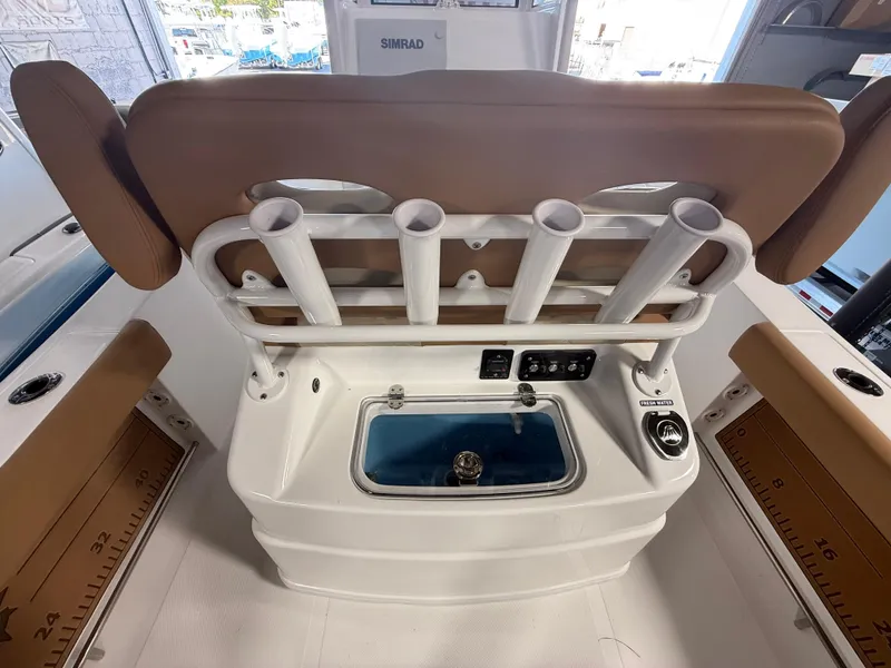 Slide: The Image of 2025 NauticStar 252 Legacy boat interior with rod holders and livewell. - 4