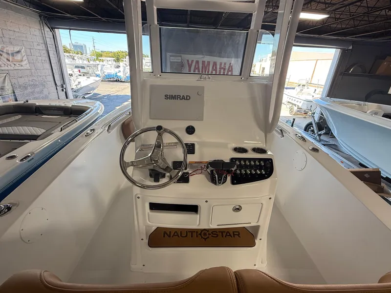 Slide: The Image of 2025 NauticStar 252 Legacy boat console with steering wheel and Simrad display. - 5