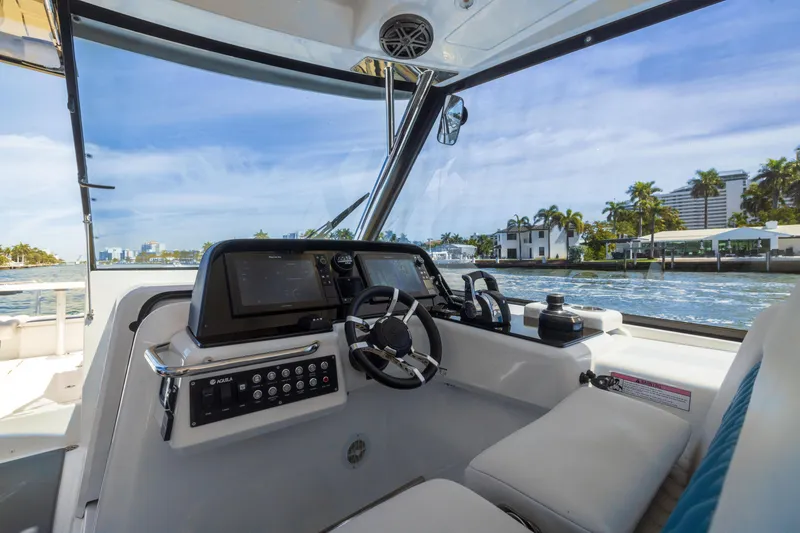 Slide: The Image of Interior view of 2019 Aquila 36 Sport boat with modern dashboard and waterfront scenery. - 14