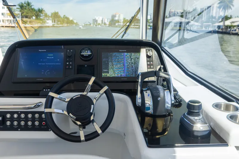 Slide: The Image of Control panel of 2019 Aquila 36 Sport boat with steering wheel and navigation screens. - 15