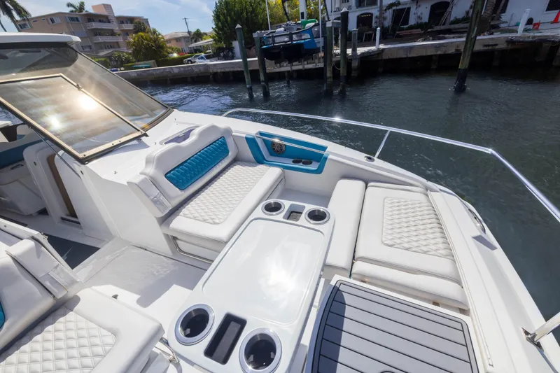 Slide: The Image of Aquila 36 Sport 2019 boat with luxurious seating and cup holders, docked by the water. - 19
