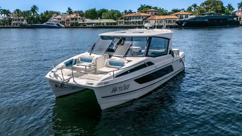 Slide: The Image of 2019 Aquila 36 Sport boat on a serene waterfront with luxury homes in the background. - 26