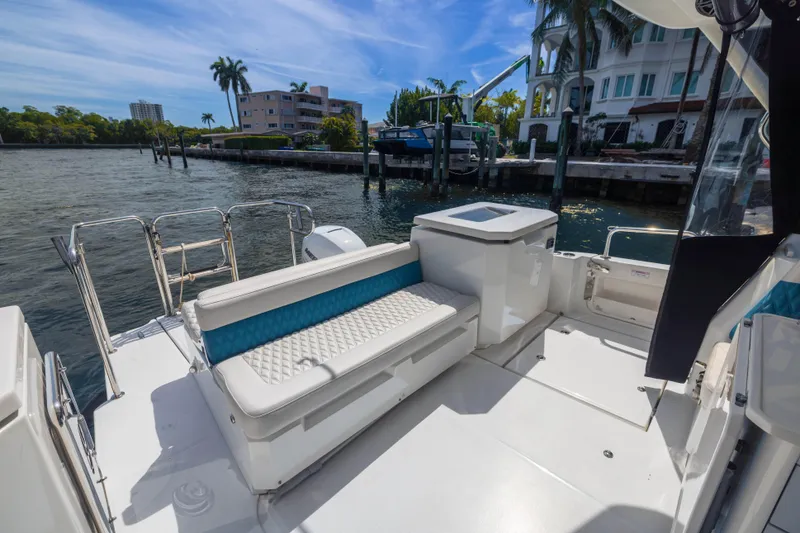 Slide: The Image of Aquila 36 Sport 2019 boat deck with seating, docked by waterfront homes. - 8