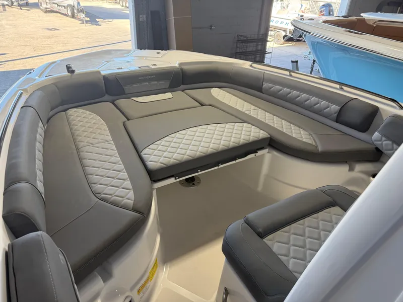 Slide: The Image of 2025 NauticStar 251 Hybrid boat interior with gray cushioned seating. - 8