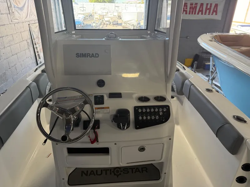 Slide: The Image of 2025 NauticStar 251 Hybrid boat console with steering wheel and Simrad display. - 9