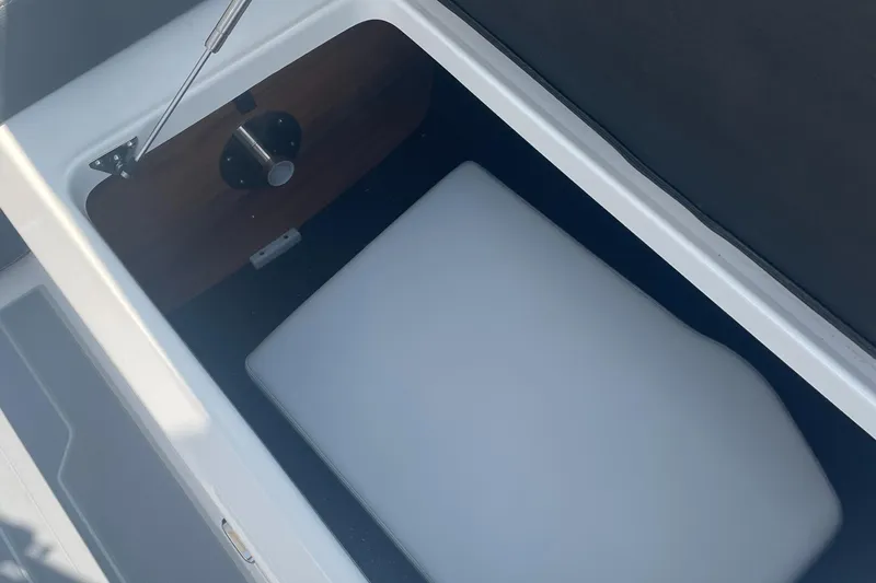Slide: The Image of 2025 Regal LS4 Surf boat storage compartment with cushioned interior. - 15