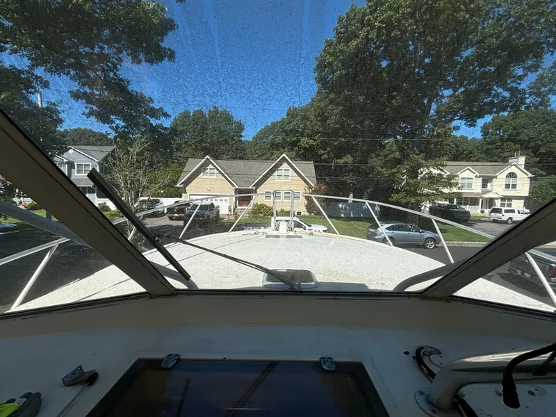 Slide: The Image of 1984 Viking Express Cruiser view from cockpit, overlooking suburban neighborhood with trees and houses. - 10