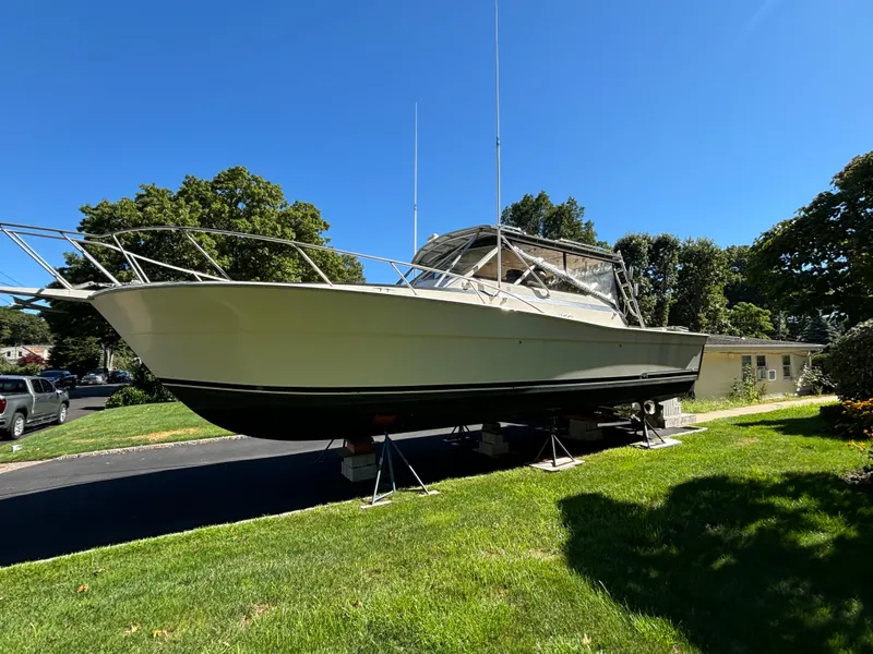 Slide: The Image of 1984 Viking Express Cruiser boat on stands, displayed outdoors on a sunny day. - 6