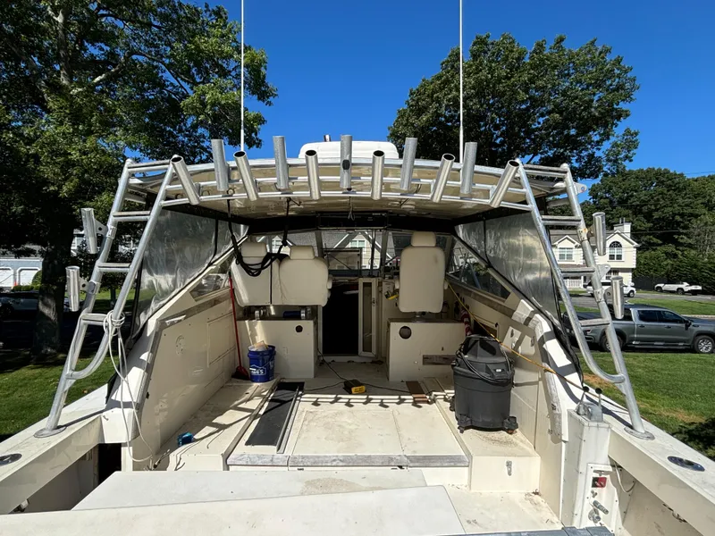 Slide: The Image of 1984 Viking Express Cruiser boat with open deck, rod holders, and seating, under clear blue sky. - 7