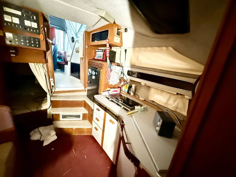 Slide: The Image of Interior of 1986 Cruisers Yachts 297 Elegante, featuring compact kitchen and control panel. - 12