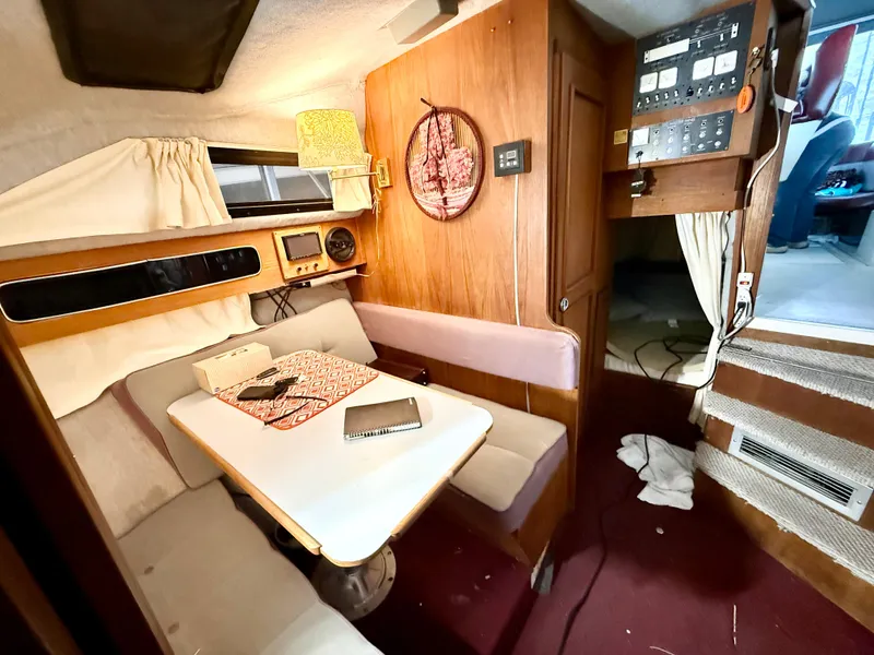 Slide: The Image of Interior of 1986 Cruisers Yachts 297 Elegante, featuring cozy seating and a dining area. - 13