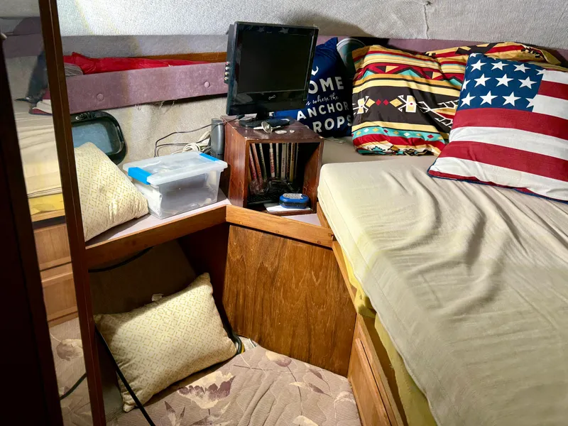 Slide: The Image of 1986 Cruisers Yachts 297 Elegante cabin interior with bed, pillows, and small TV. - 16