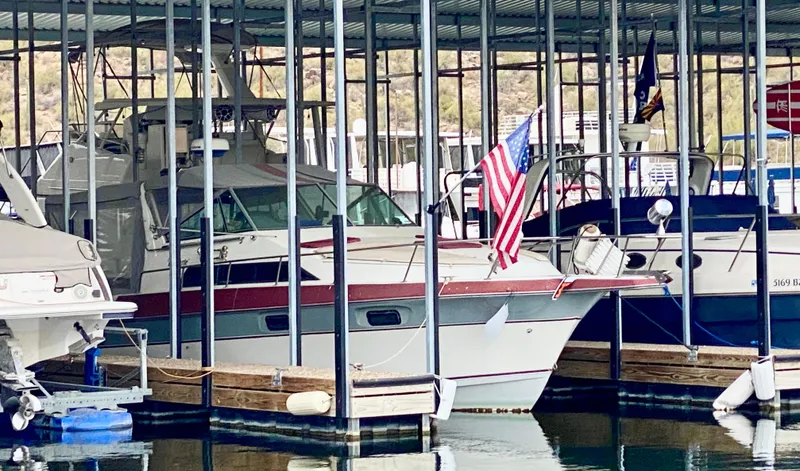 Slide: The Image of 1986 Cruisers Yachts 297 Elegante docked with American flag, under covered marina. - 17