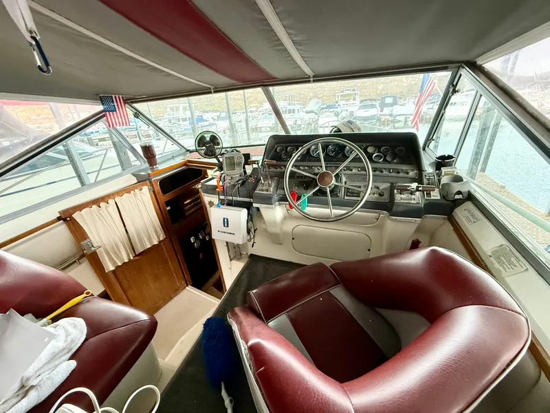 Slide: The Image of 1986 Cruisers Yachts 297 Elegante helm with maroon seats and nautical instruments. - 6