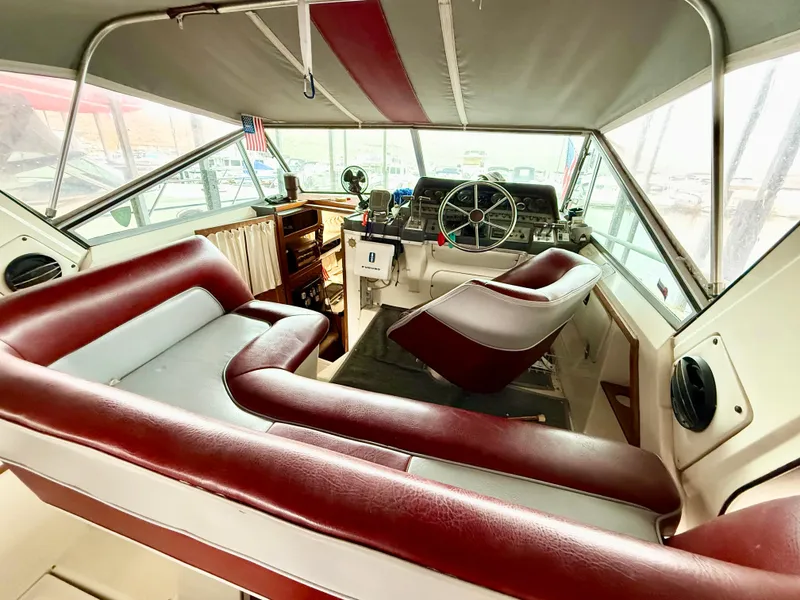 Slide: The Image of 1986 Cruisers Yachts 297 Elegante interior with red and white seating, helm, and dashboard. - 8