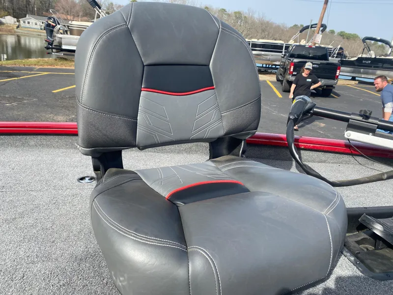 Slide: The Image of 2022 Tracker Pro Team 175 TXW boat seat, gray with red accents, in a parking lot. - 13