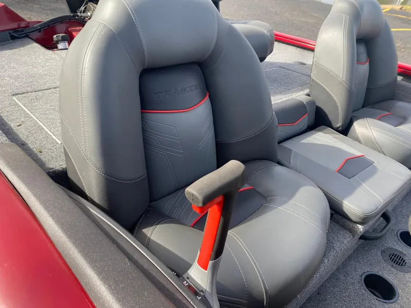 Slide: The Image of 2022 Tracker Pro Team 175 TXW boat seats, gray with red accents, on a textured deck. - 16