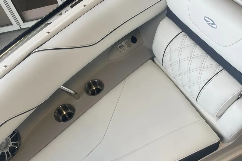Slide: The Image of 2025 Regal LS4 Surf boat interior with white leather seating and cup holders. - 10
