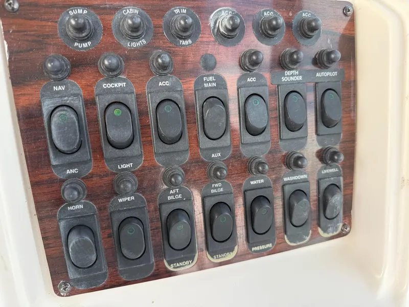 Slide: The Image of Control panel of a 2001 Grady-White Sailfish 274 boat with various switches and toggles. - 21