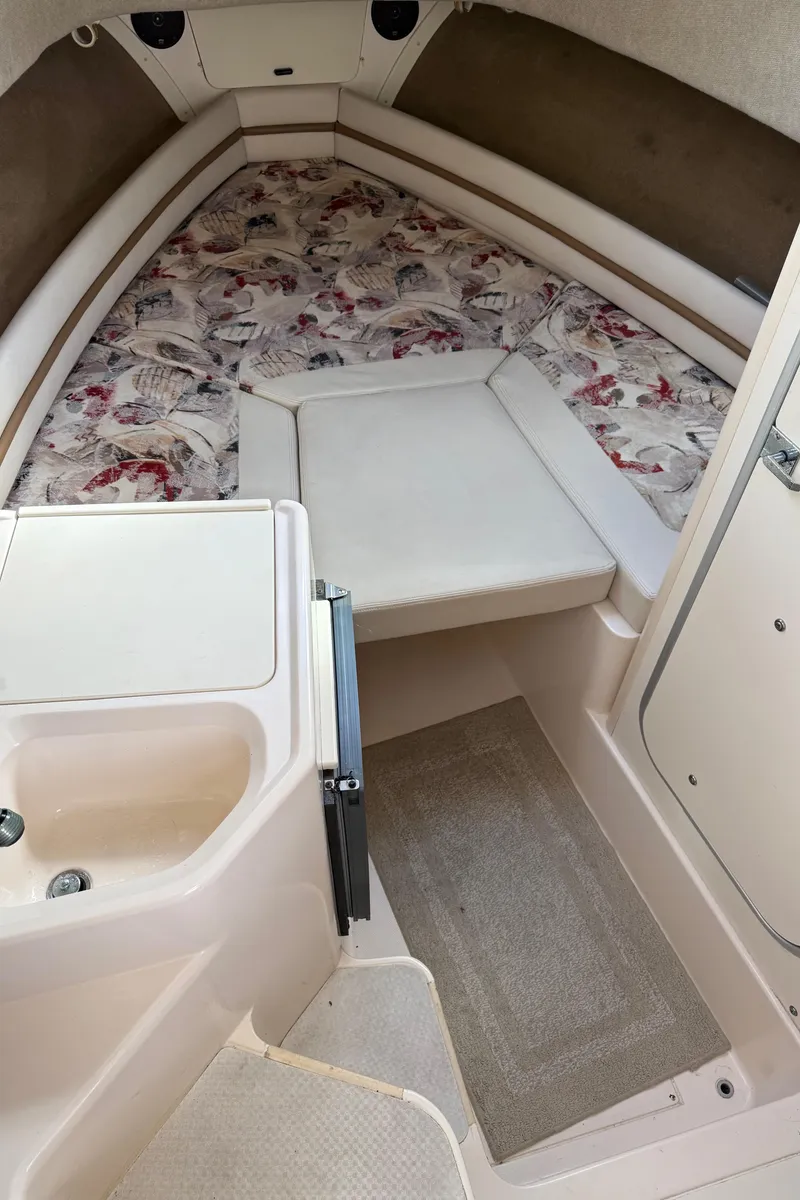 Slide: The Image of 2001 Grady-White Sailfish 274 cabin interior with patterned cushions and compact sink. - 27