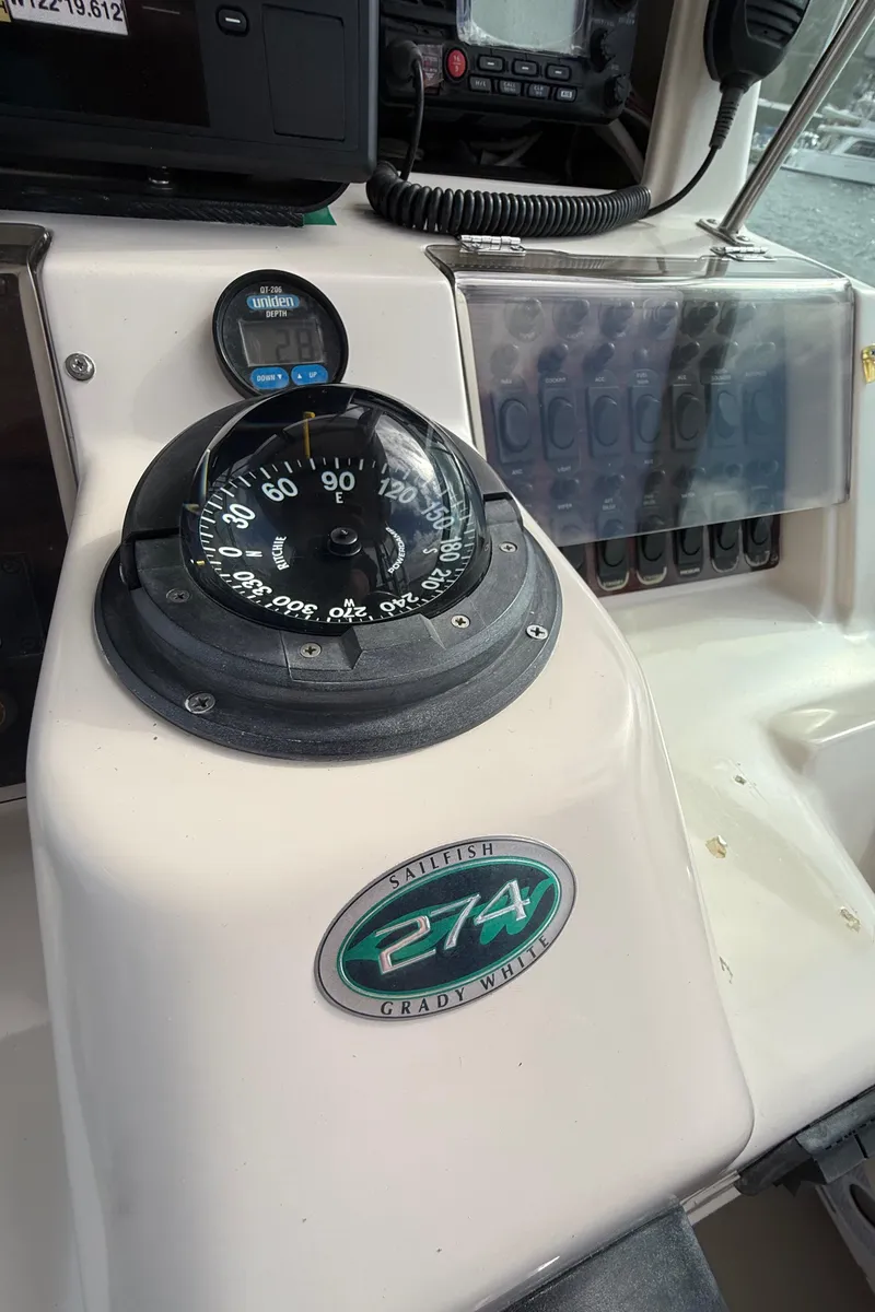 Slide: The Image of 2001 Grady-White Sailfish 274 boat dashboard with compass and controls. - 32