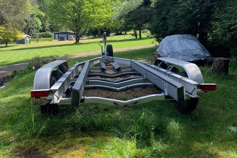 Slide: The Image of Trailer for 1999 Grady-White Sailfish 274 on grassy yard, surrounded by trees. - 42
