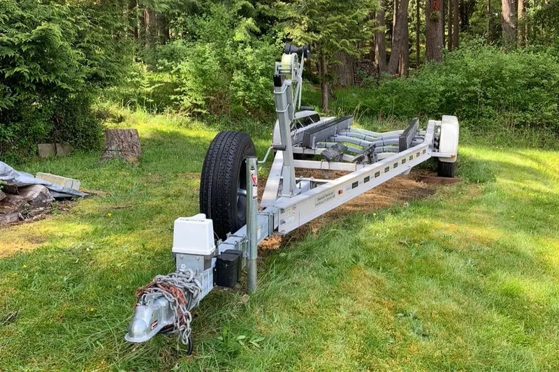 Slide: The Image of Trailer for 1999 Grady-White Sailfish 274 in a grassy area with trees. - 43
