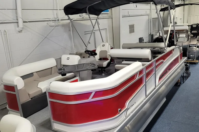 The Image of 2025 Princecraft Vectra 21 RL pontoon boat with red and white design in showroom. - 0