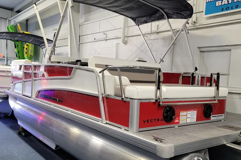Slide: The Image of 2025 Princecraft Vectra 21 RL pontoon boat with red and white design in showroom. - 12