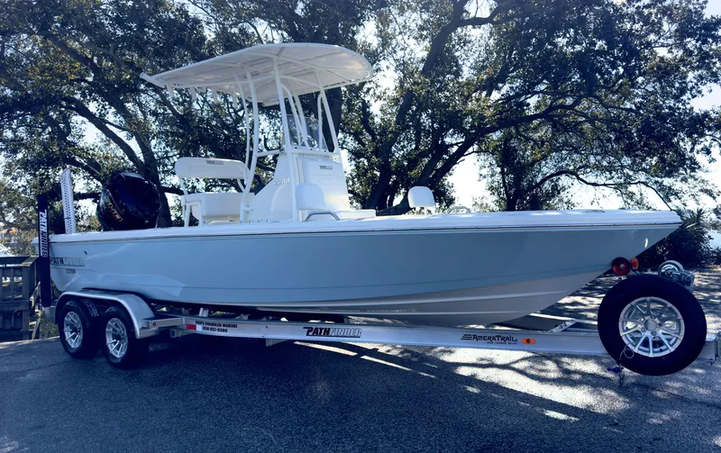 The Image of 2025 Pathfinder 2200TRS boat on trailer, parked under trees, side view. - 0