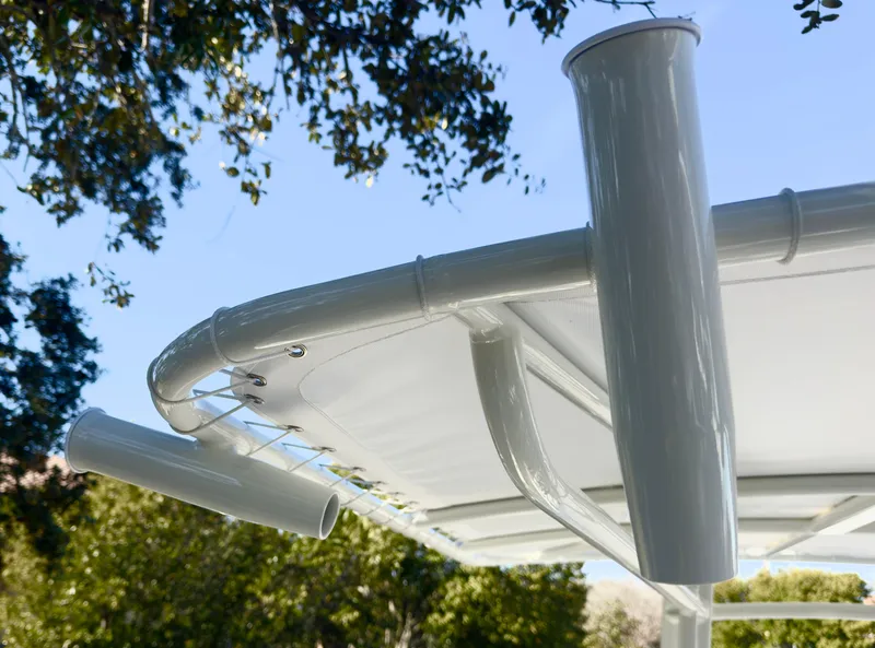 Slide: The Image of 2025 Pathfinder 2200TRS boat T-top with rod holders against a clear sky. - 17