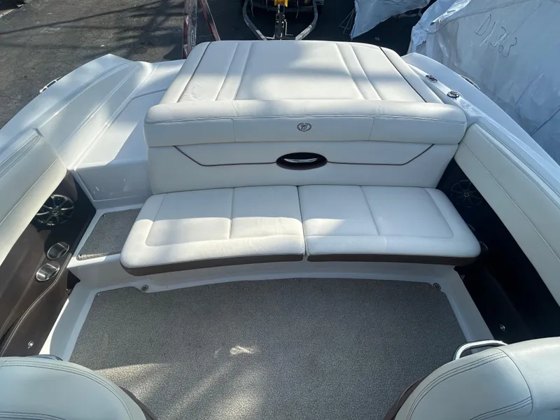 Slide: The Image of 2012 Cobalt 210 WSS boat interior with white cushioned seating and carpeted floor. - 9