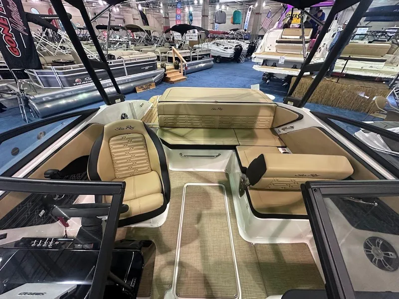 Slide: The Image of 2025 Sea Ray SPX 190 boat interior with beige seating at a boat show. - 20