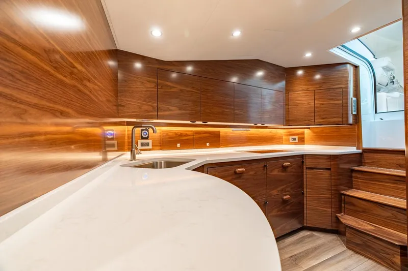 Slide: The Image of Luxurious interior of 2025 Viking 54 Sport Tower yacht, featuring sleek wood cabinetry and modern lighting. - 29