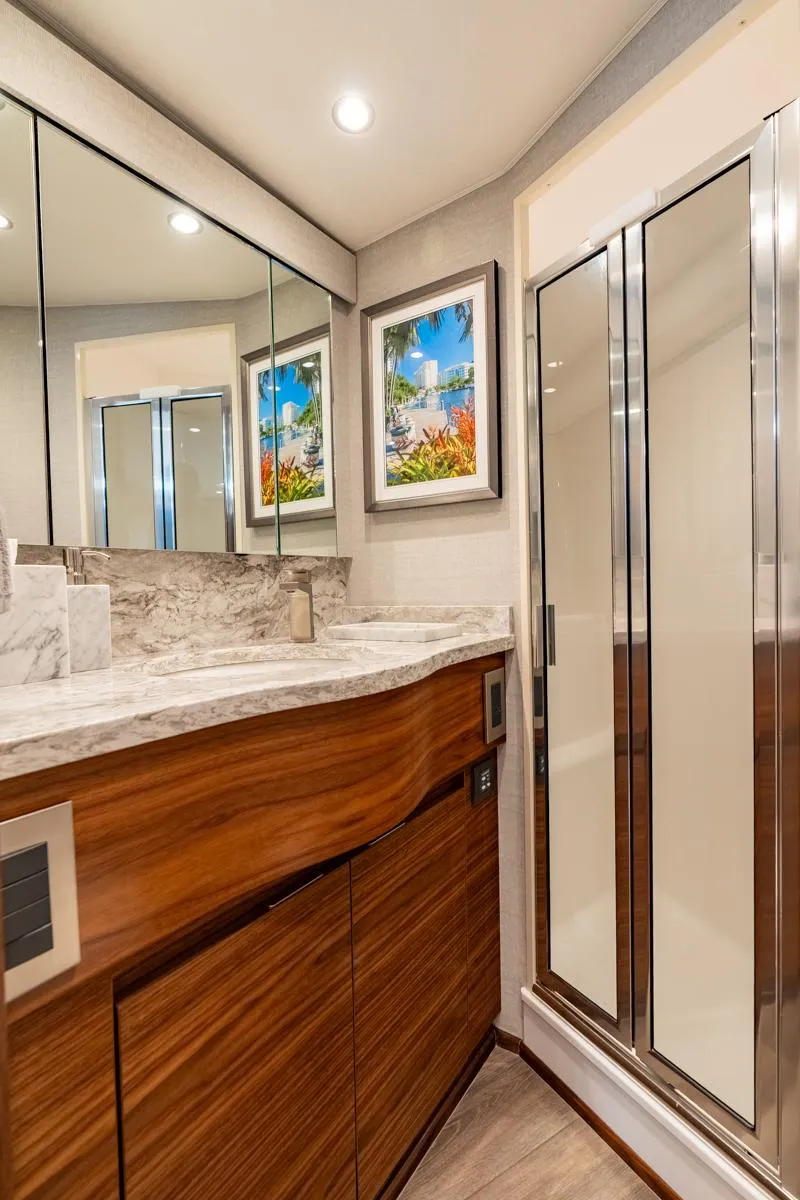 Slide: The Image of Luxurious bathroom in 2025 Viking 54 Sport Tower yacht, featuring modern wood cabinetry and glass shower. - 35