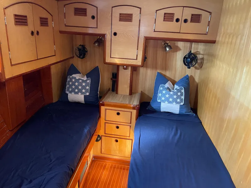 Slide: The Image of 1981 Little Harbor Cruiser cabin with twin beds, blue bedding, and wooden cabinetry. - 10