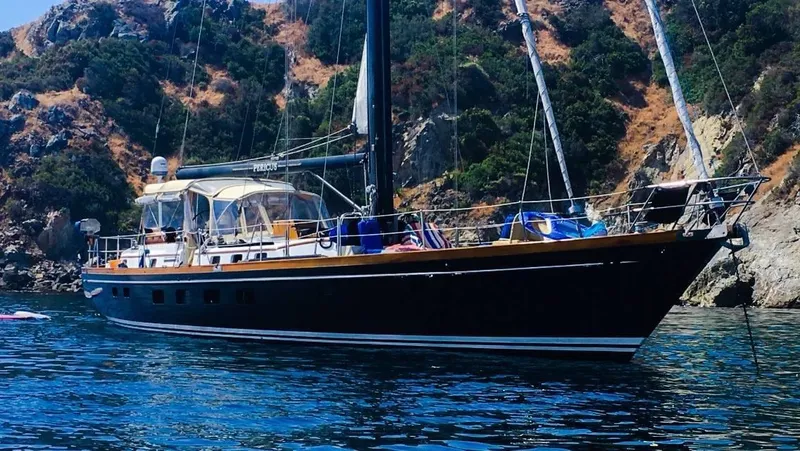 The Image of 1981 Little Harbor Cruiser yacht anchored near rocky coastline. - 0