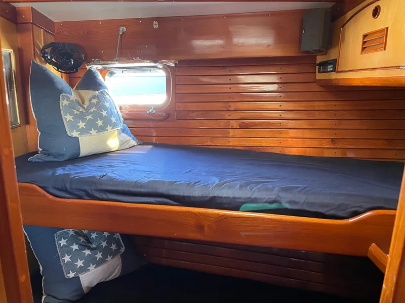 Slide: The Image of 1981 Little Harbor Cruiser cabin with twin beds, blue bedding, and wooden cabinetry. - 11