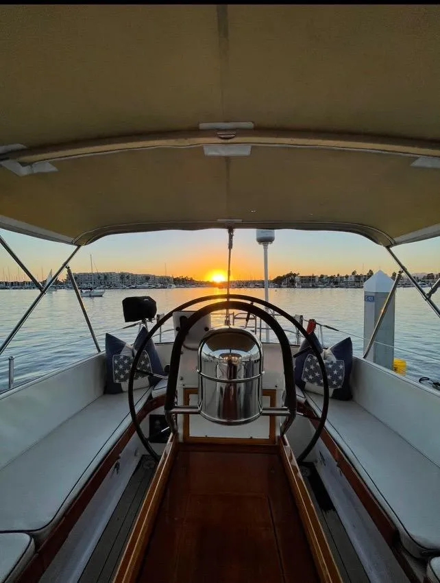 Slide: The Image of 1981 Little Harbor Cruiser at sunset, featuring a spacious deck and serene marina view. - 4