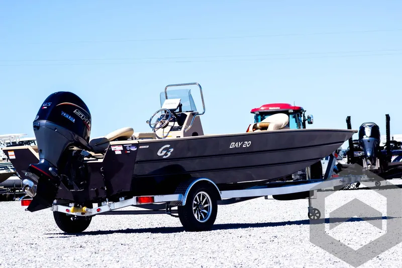 Slide: The Image of 2025 G3 Bay 20 boat on trailer, parked outdoors under clear blue sky. - 6